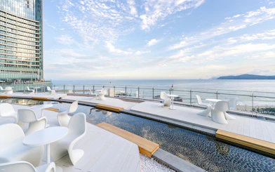 Outdoor terrace at Club D Oasis with modern seating and shallow water features by the sea.