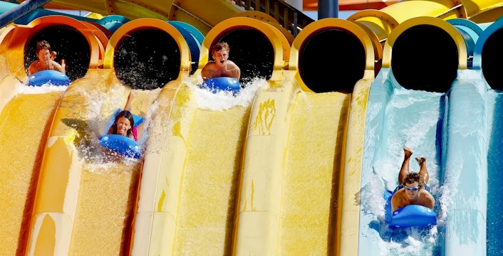Visitors racing down water slides at Wahoo Racer, Hurricane Harbor, Six Flags Chicago.
