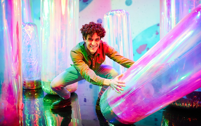 Man interacting with colorful inflatable tubes at Bubble Planet, Washington DC.