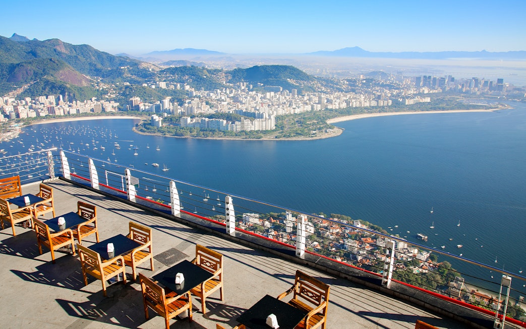View of Rio de Janeiro coastline from Sugarloaf Mountain, Brazil, with seating area in foreground.