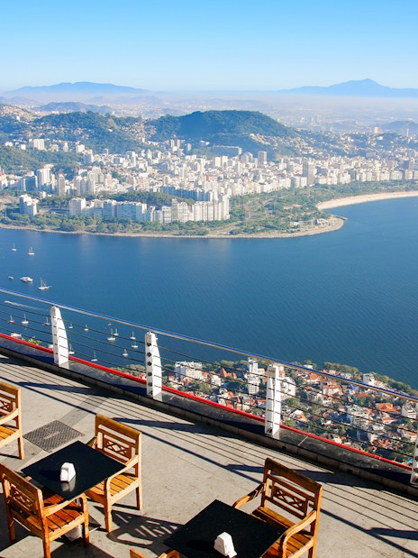 View of Rio de Janeiro coastline from Sugarloaf Mountain, Brazil, with seating area in foreground.