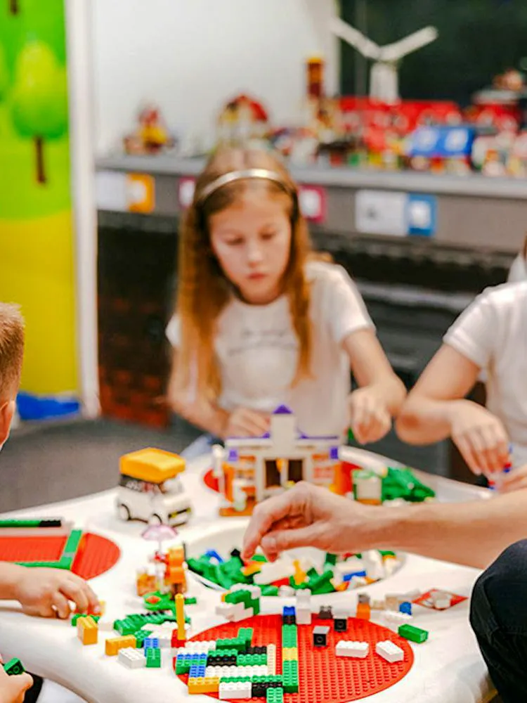 Children building with colorful bricks at Museum of Bricks exhibit.