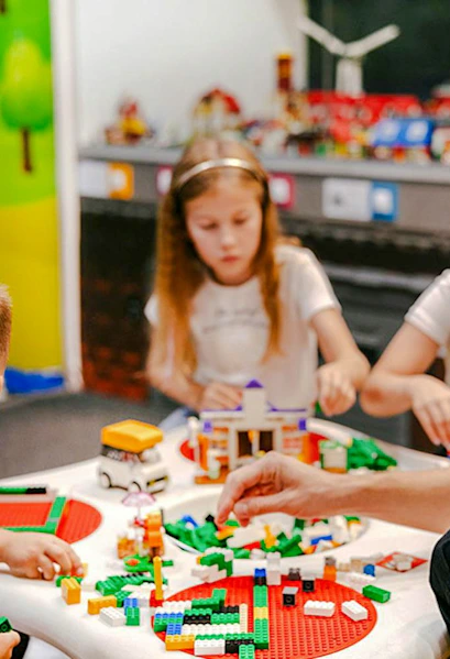 Children building with colorful bricks at Museum of Bricks exhibit.