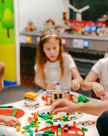 Children building with colorful bricks at Museum of Bricks exhibit.