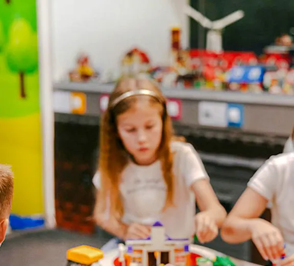 Children building with colorful bricks at Museum of Bricks exhibit.