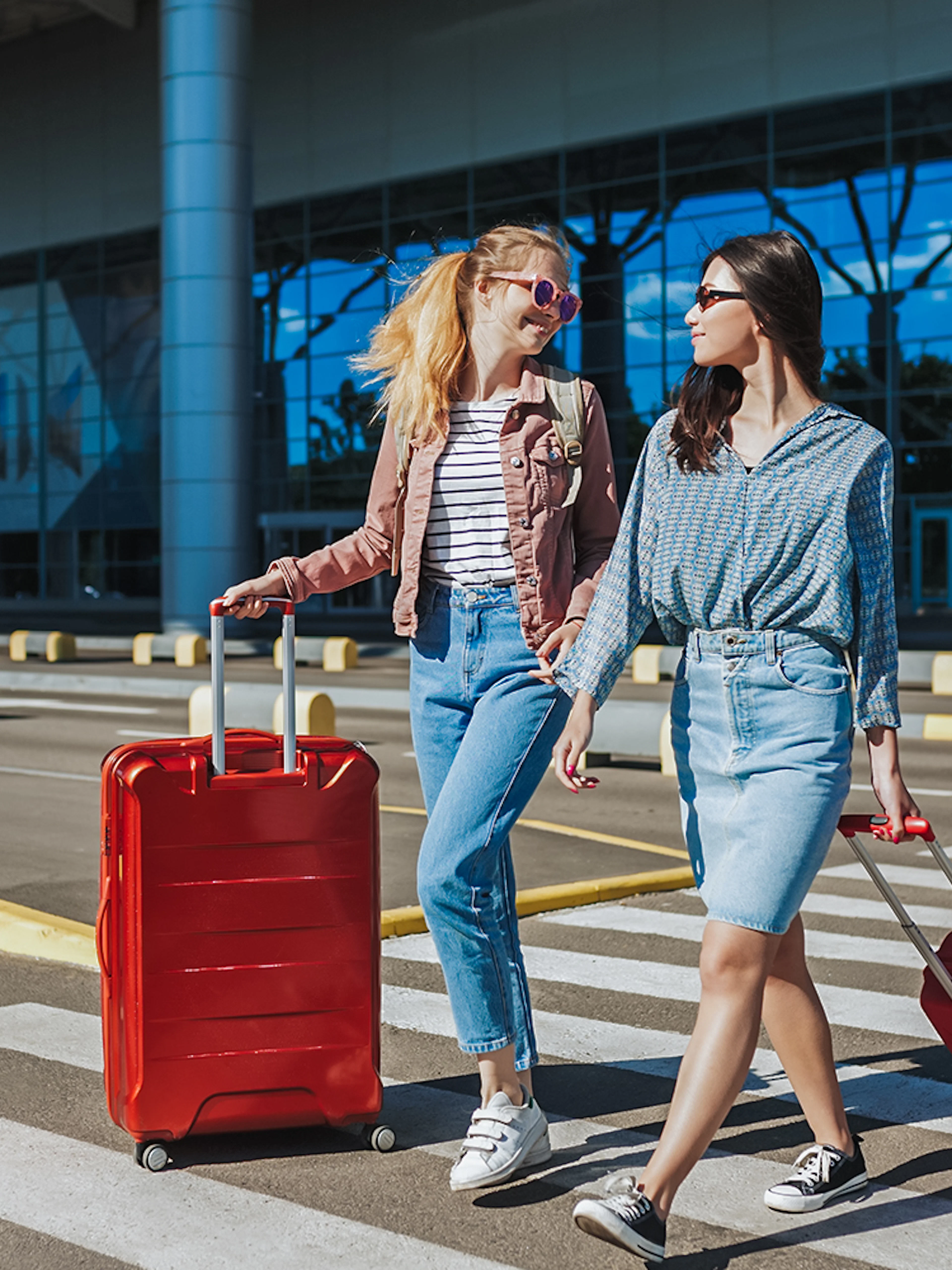Travelers with luggage outside Singapore Changi Airport for private car transfer.