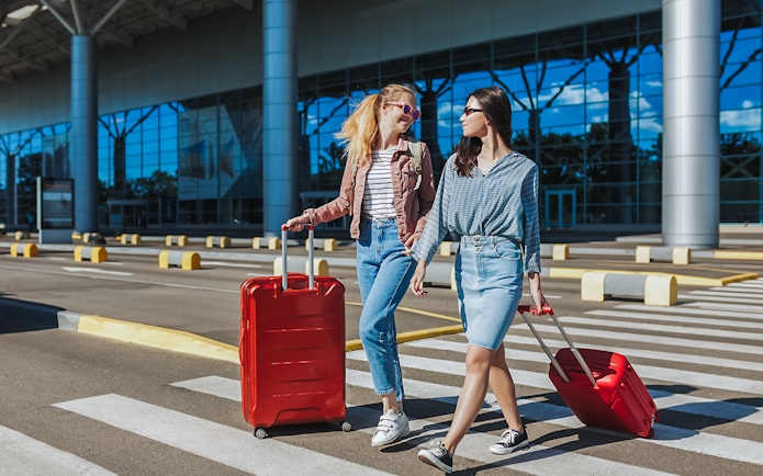 Travelers with luggage outside Singapore Changi Airport for private car transfer.