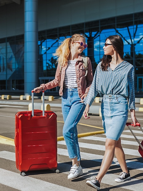 Travelers with luggage outside Singapore Changi Airport for private car transfer.