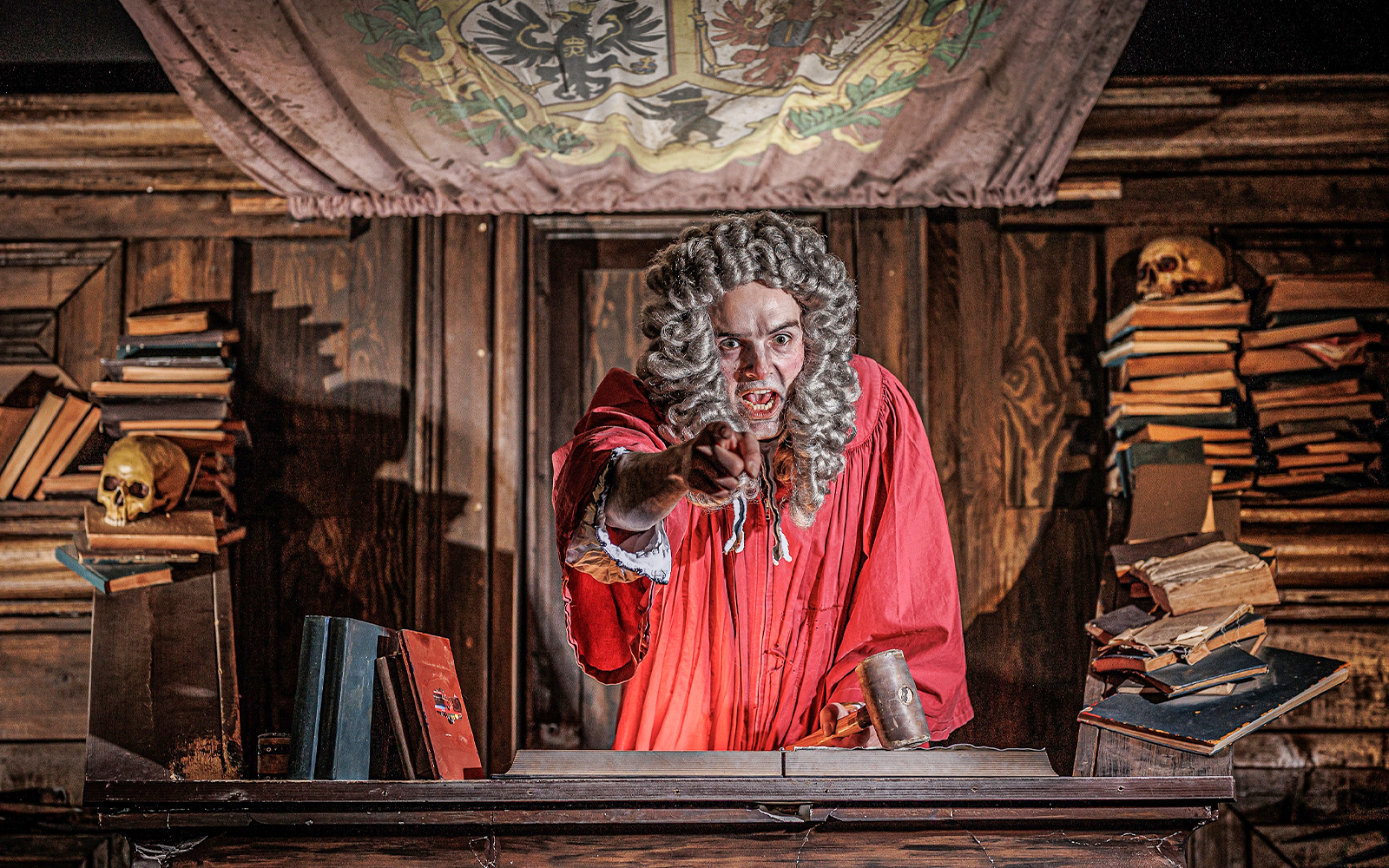 Judge in historical attire at Berlin Dungeon courtroom exhibit.