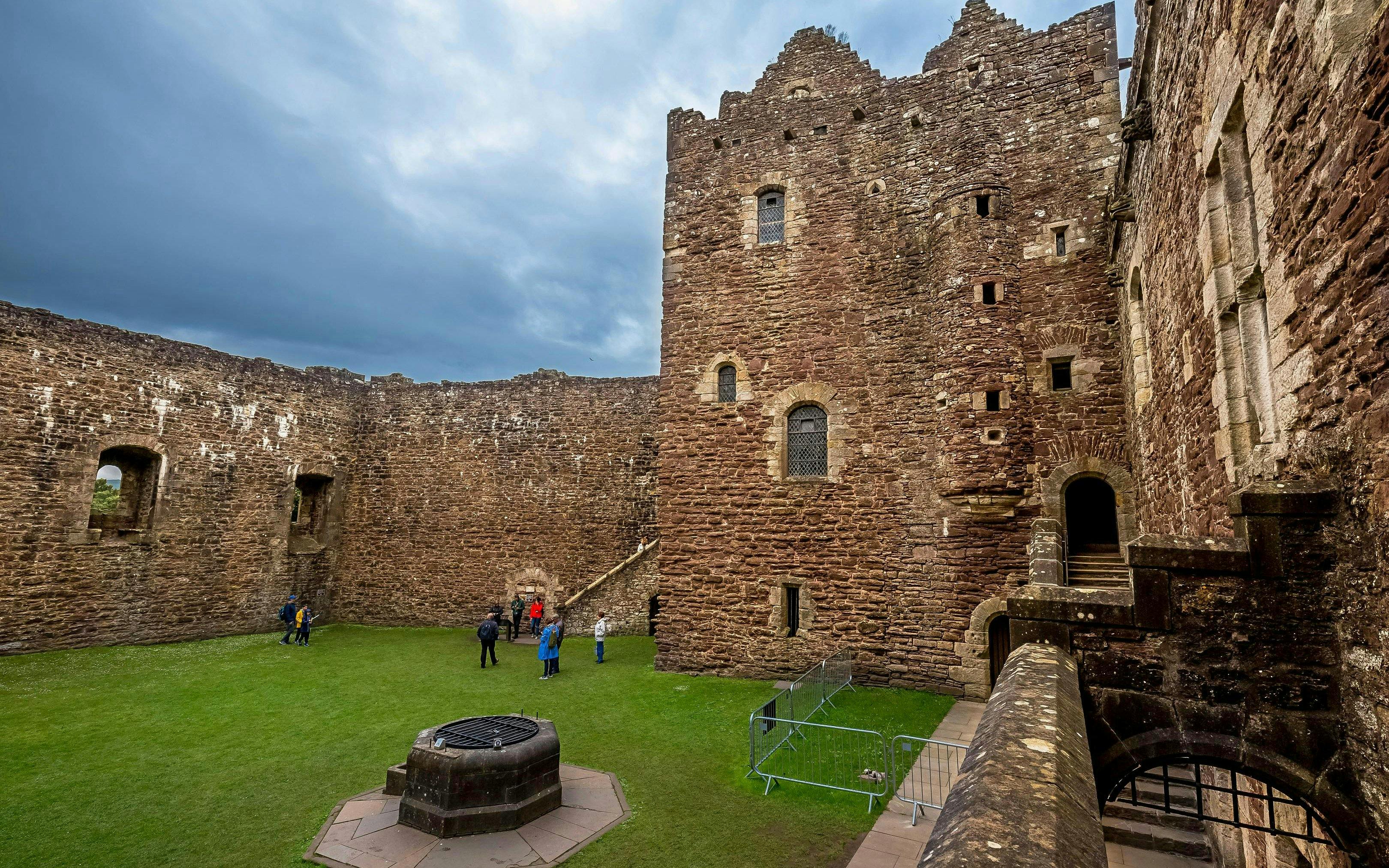 Visitors exploring the courtyard of Doune Castle, Scotland.