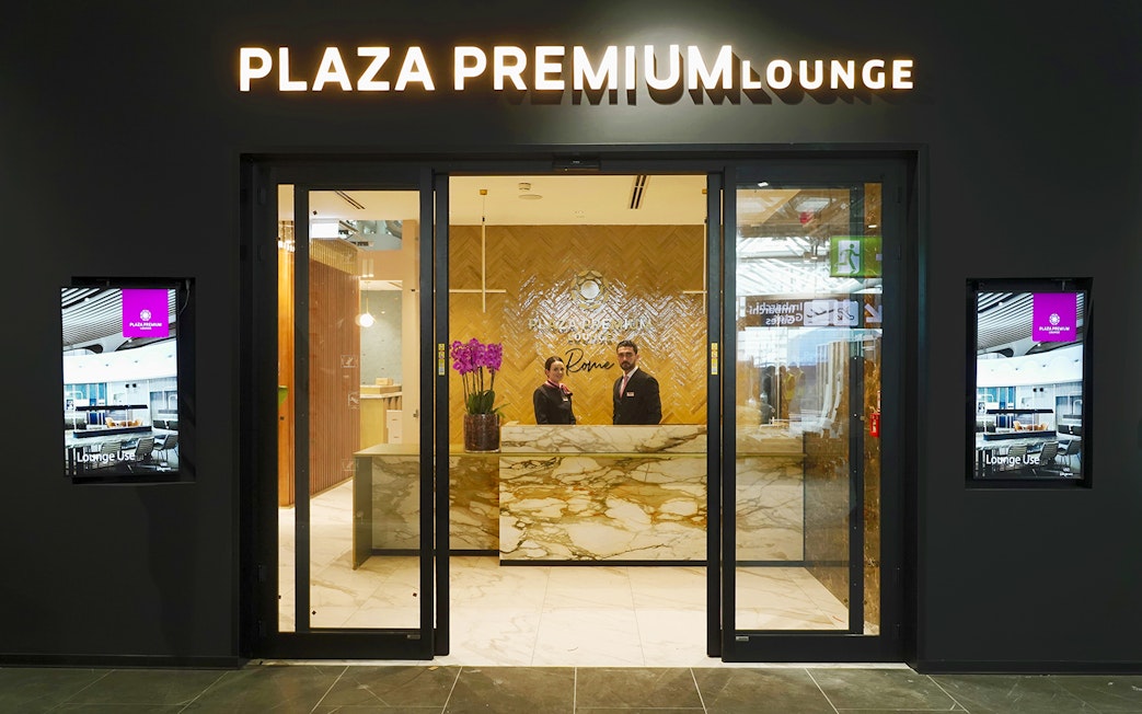 Plaza Premium Lounge entrance at Rome Fiumicino Airport with staff at reception.