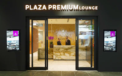 Plaza Premium Lounge entrance at Rome Fiumicino Airport with staff at reception.
