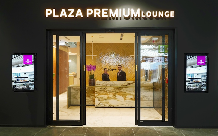 Plaza Premium Lounge entrance at Rome Fiumicino Airport with staff at reception.