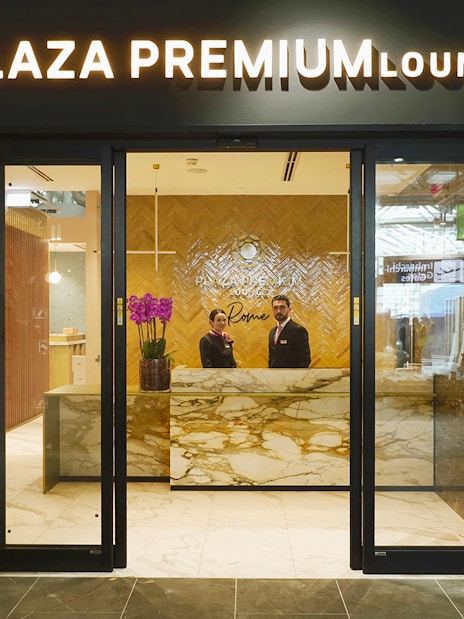 Plaza Premium Lounge entrance at Rome Fiumicino Airport with staff at reception.