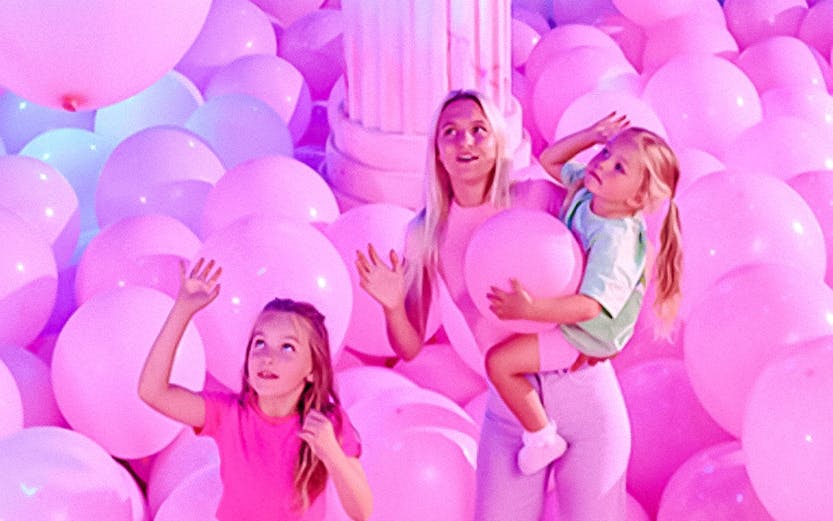 Visitors in a room filled with pink balloons at Bubble Planet An Experience Museum.