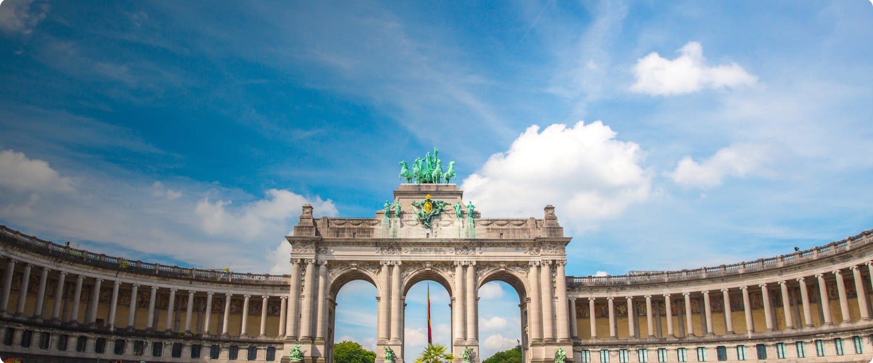 Triumphal Arch at Cinquantenaire Park in Brussels under a blue sky.