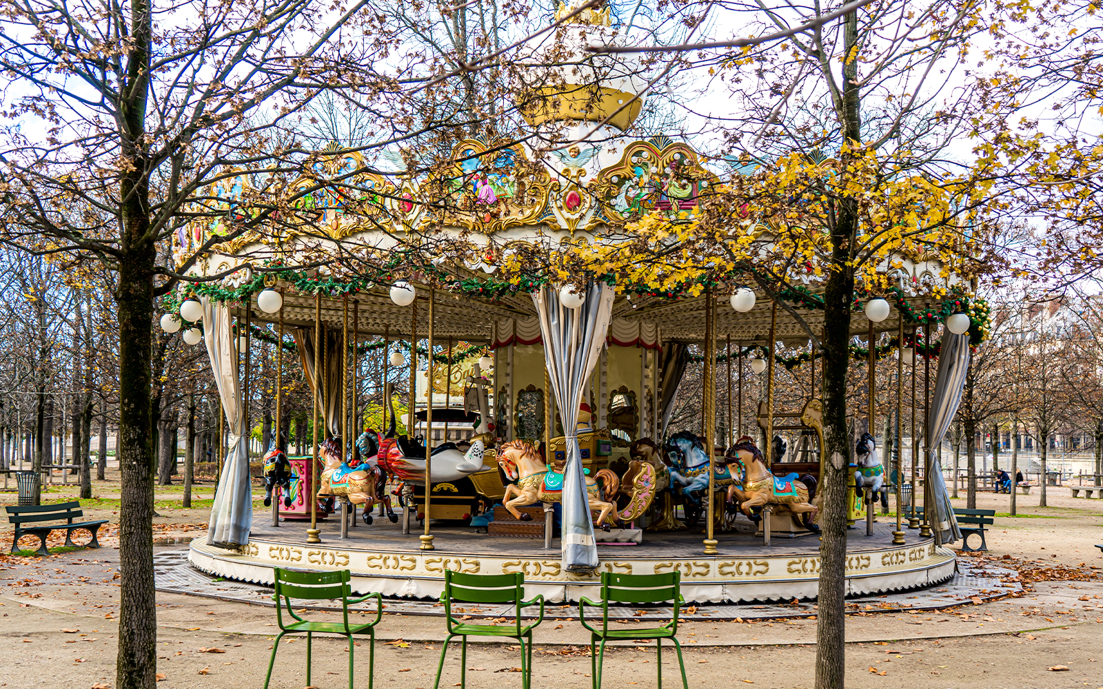 Carousel in Tuileries Garden, Paris, surrounded by autumn trees.