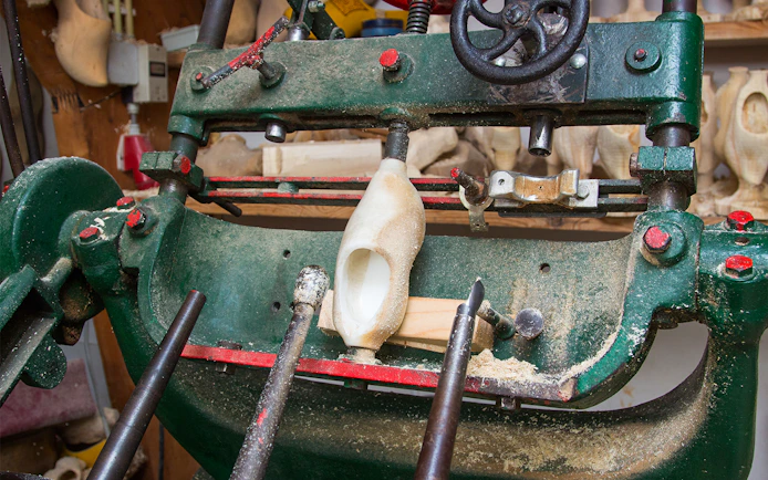 Wooden clog being crafted on a machine in Zaanse Schans, Netherlands.