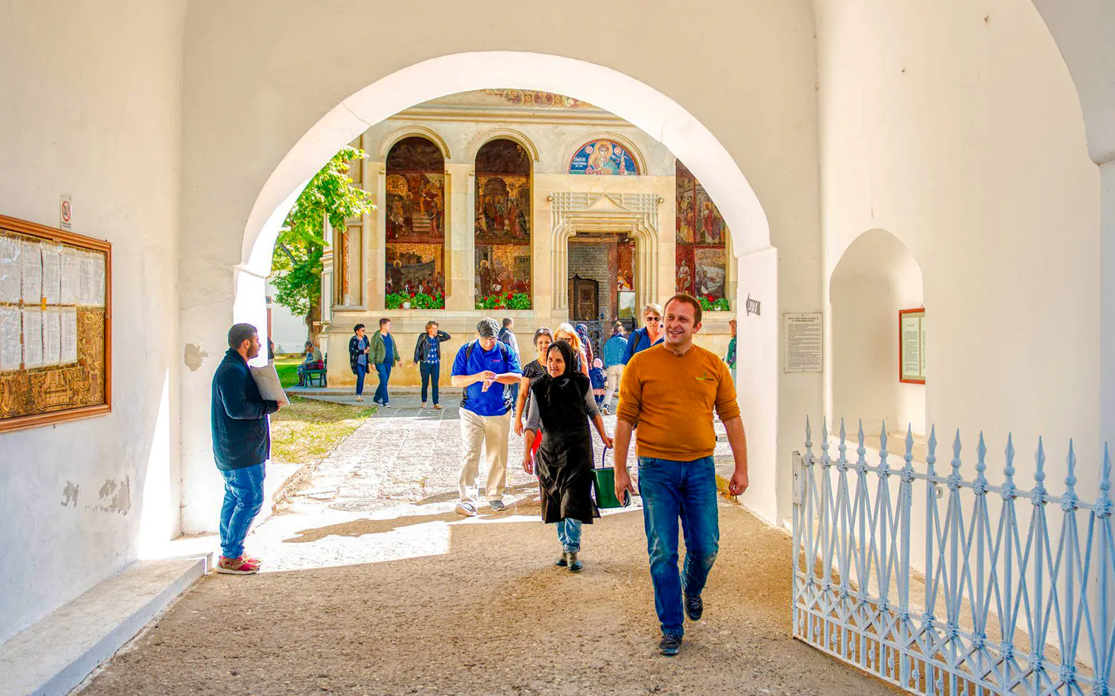 Tour group exploring Snagov Monastery courtyard, Romania.