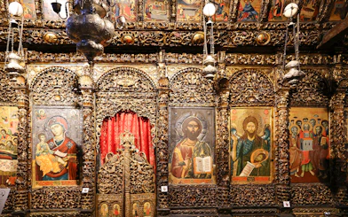 Iconography inside the Onufri National Iconographic Museum in Berat, featuring religious paintings and ornate carvings.