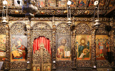 Iconography inside the Onufri National Iconographic Museum in Berat, featuring religious paintings and ornate carvings.
