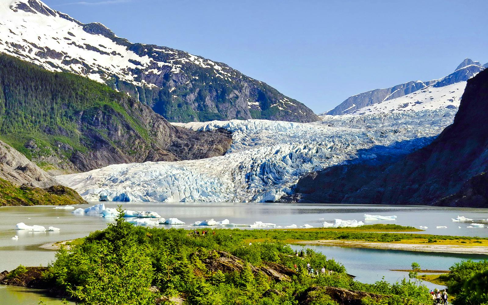 Mendenhall Glacier in Alaska with surrounding mountains and icy lake.