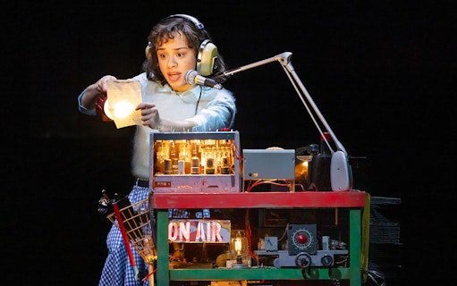 Person using a vintage radio setup with headphones and microphone, related to Stranger Things.