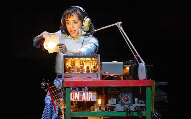 Person using a vintage radio setup with headphones and microphone, related to Stranger Things.