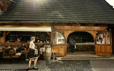 Zakopane street scene with people outside a traditional wooden shop.