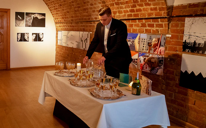 Server preparing drinks for Chopin recital at Old Town venue.