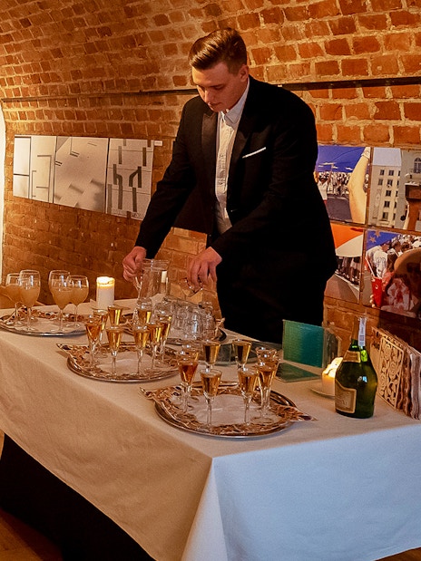 Server preparing drinks for Chopin recital at Old Town venue.