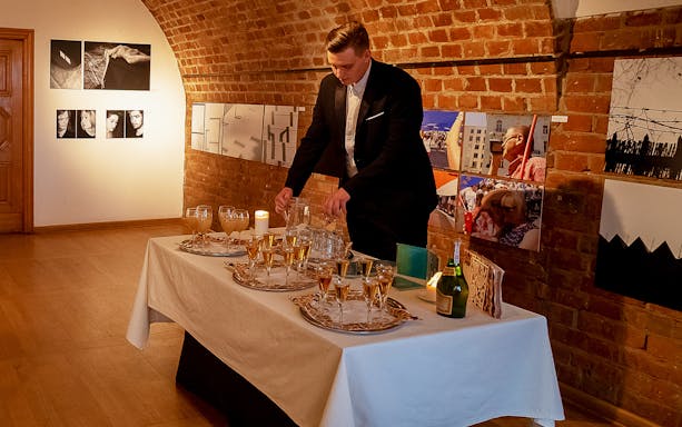 Server preparing drinks for Chopin recital at Old Town venue.