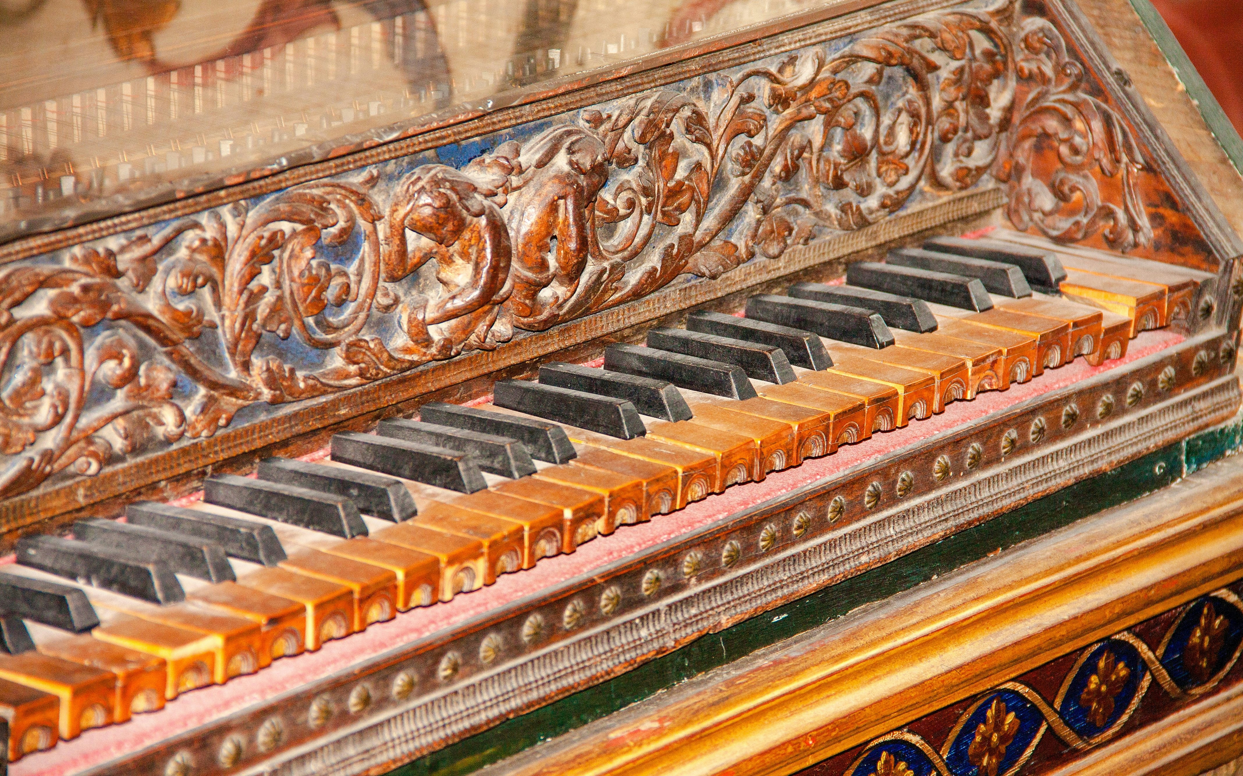 Ornate harpsichord keyboard with intricate wood carvings.