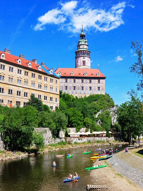 Cesky Krumlov Castle exterior with kayakers on the Vltava River.