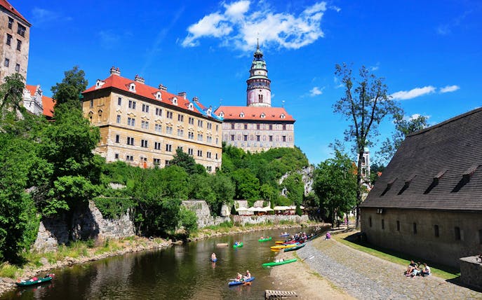 Cesky Krumlov Castle exterior with kayakers on the Vltava River.