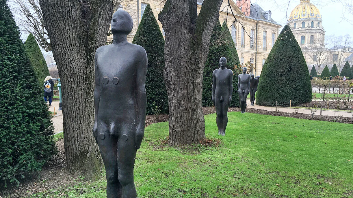 Sculptures in the garden of the Rodin Museum, Paris, with historic building in background.