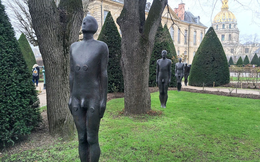 Sculptures in the garden of the Rodin Museum, Paris, with historic building in background.