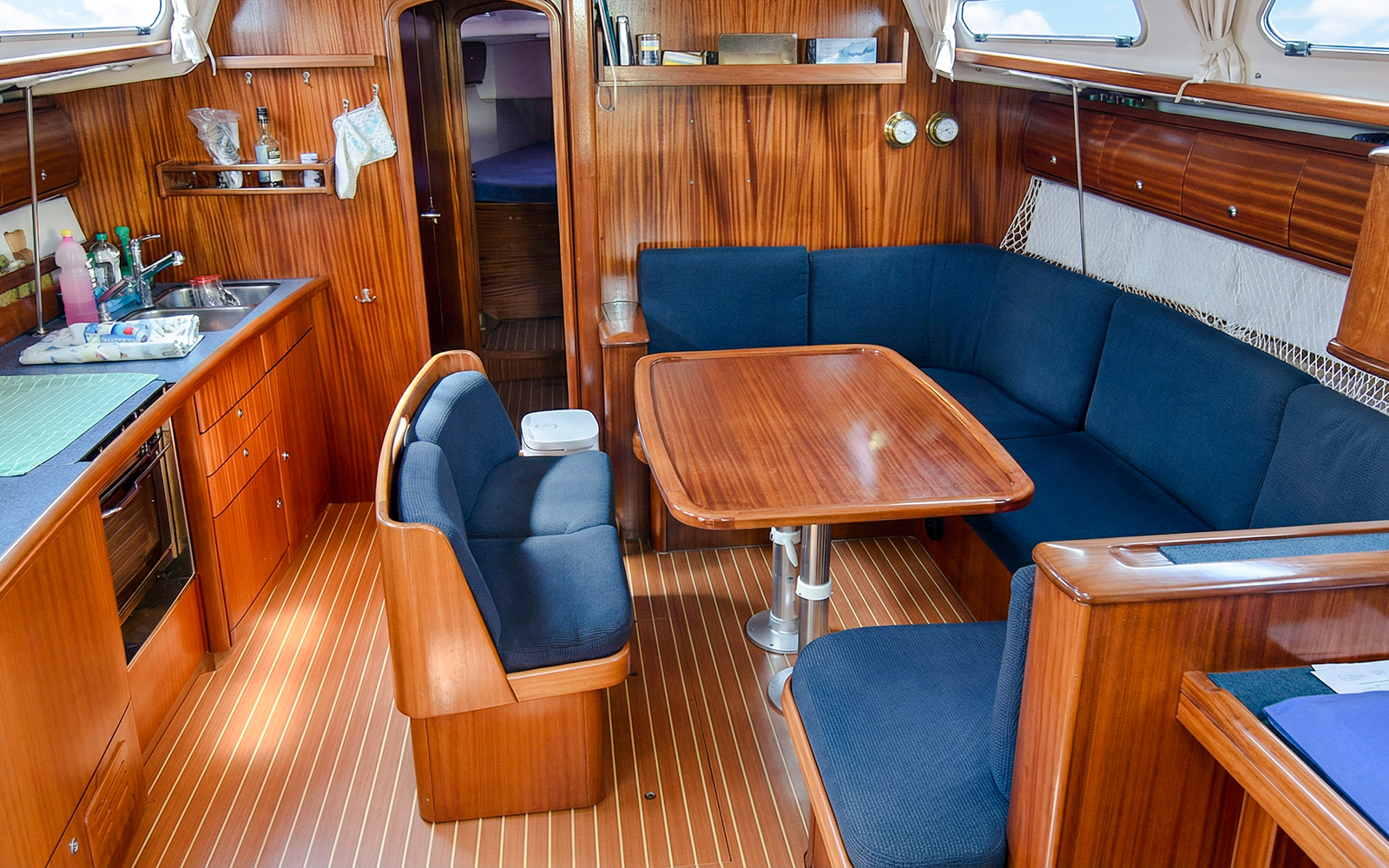 Sailboat interior with dining area and kitchen, La Maddalena Archipelago excursion.