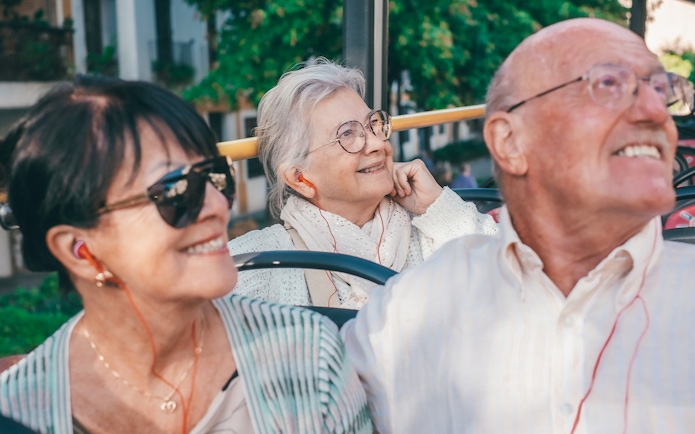 People enjoying audio guide on Marseille hop-on hop-off tour bus.