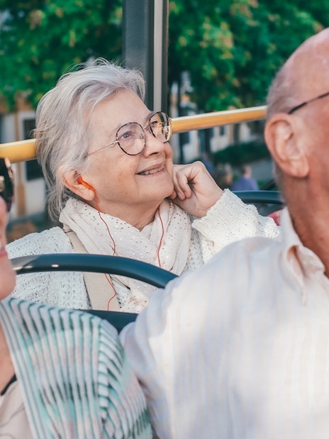 People enjoying audio guide on Marseille hop-on hop-off tour bus.