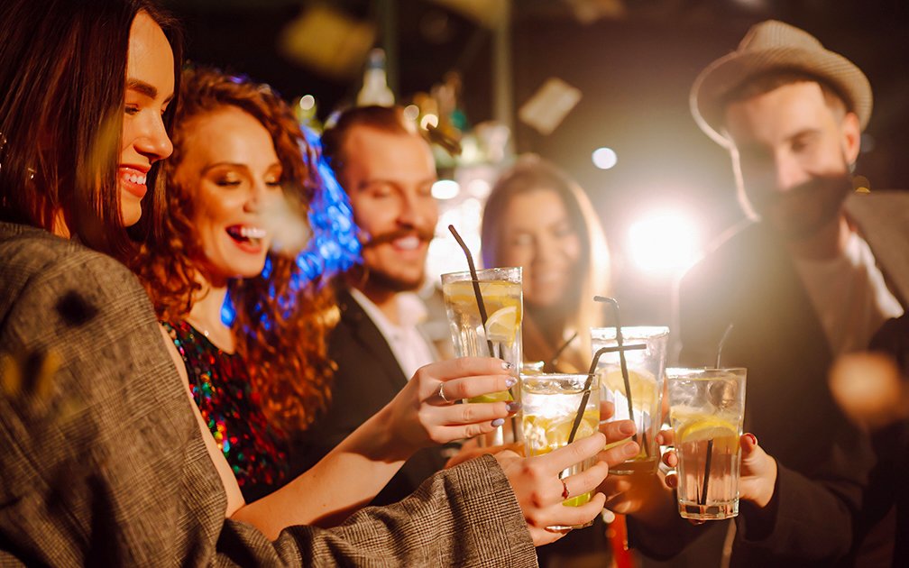 Group of friends toasting with drinks at a New Year's Eve party.