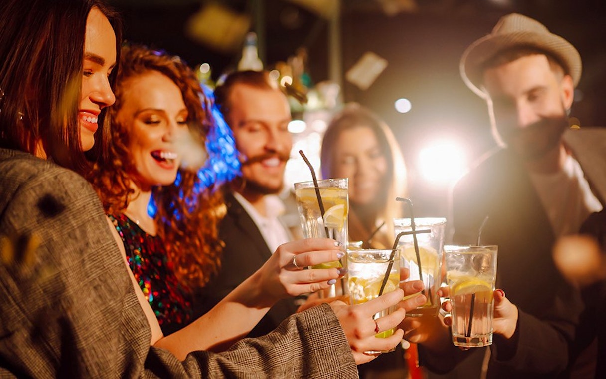 Group of friends toasting with drinks at a New Year's Eve party.