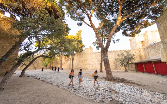 Visitors walking along the cobblestone path inside St. George’s Castle, Lisbon.