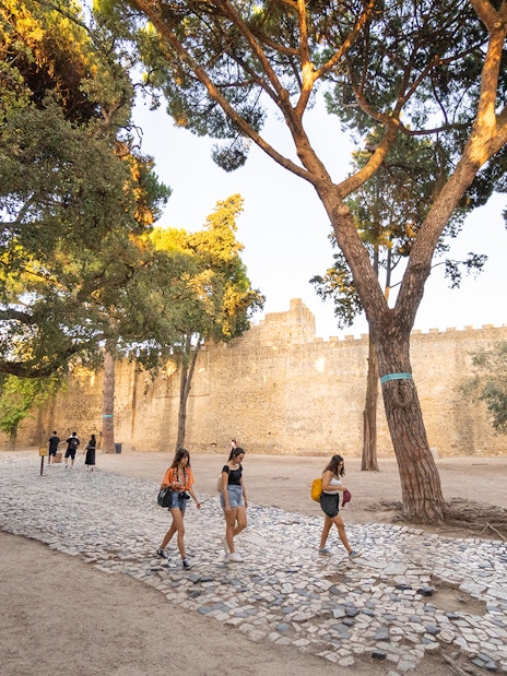 Visitors walking along the cobblestone path inside St. George’s Castle, Lisbon.