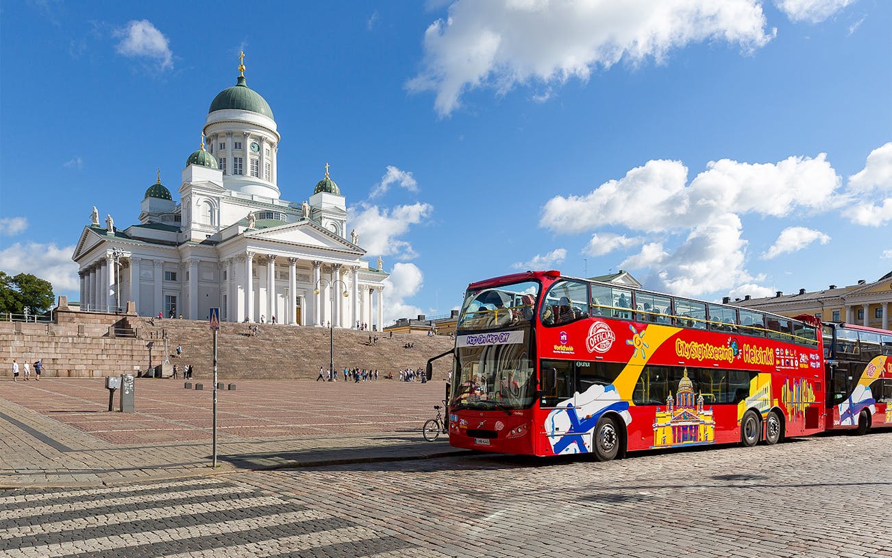 Hop-on hop-off bus in front of Helsinki Cathedral on a sunny day.