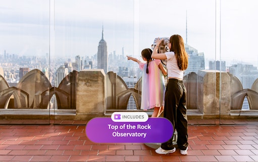 Visitors enjoying the view from Top of the Rock Observatory, New York City skyline in background.