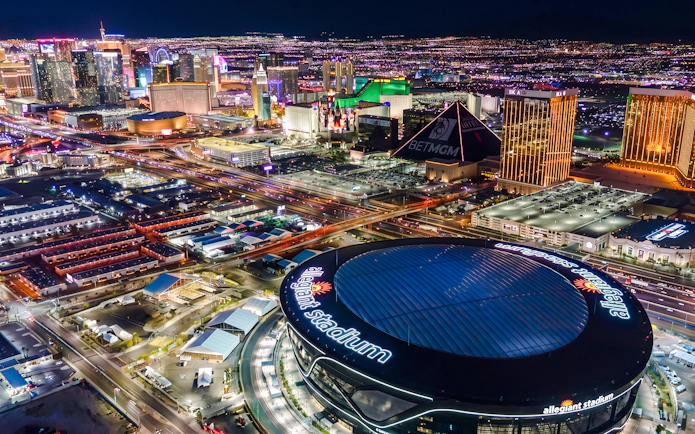 Aerial view of Allegiant Stadium and Las Vegas Strip at night during helicopter tour.