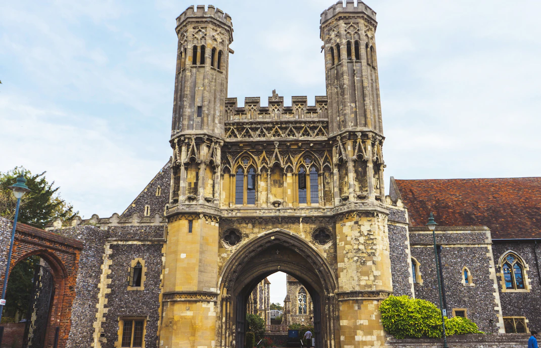 Entrance gate of The King's School Canterbury with historic architecture.