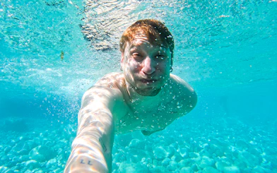 Underwater view of a person swimming in clear Capri waters during a kayak tour.