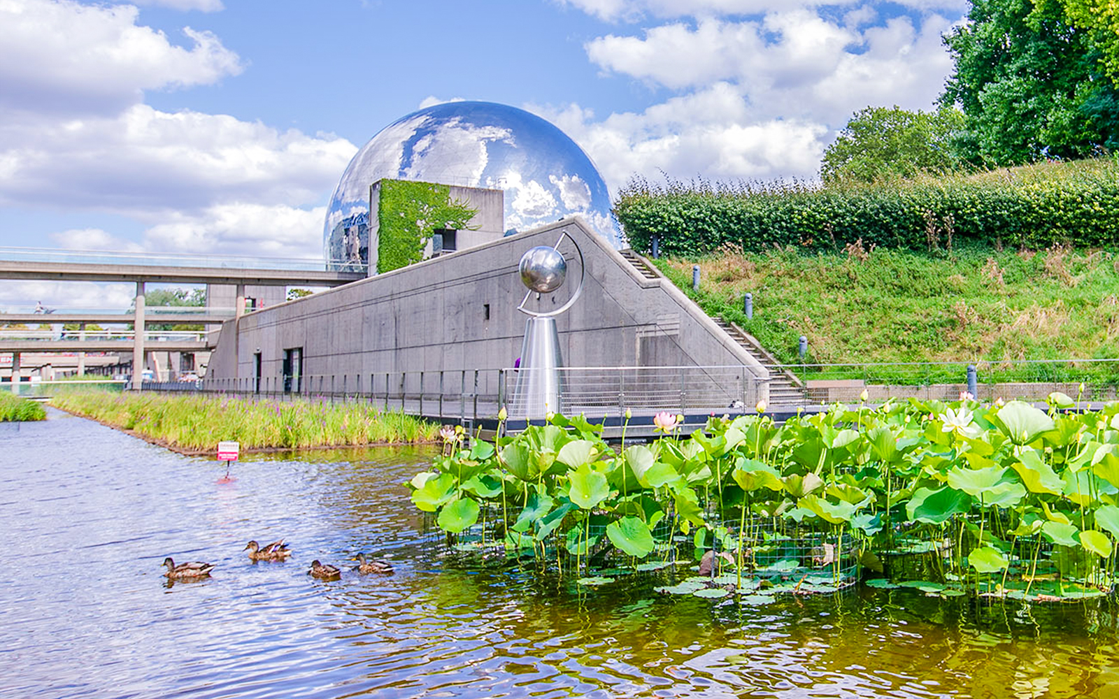 Exterior view of Science & Industry Museum with geodesic dome and pond, Paris, France.